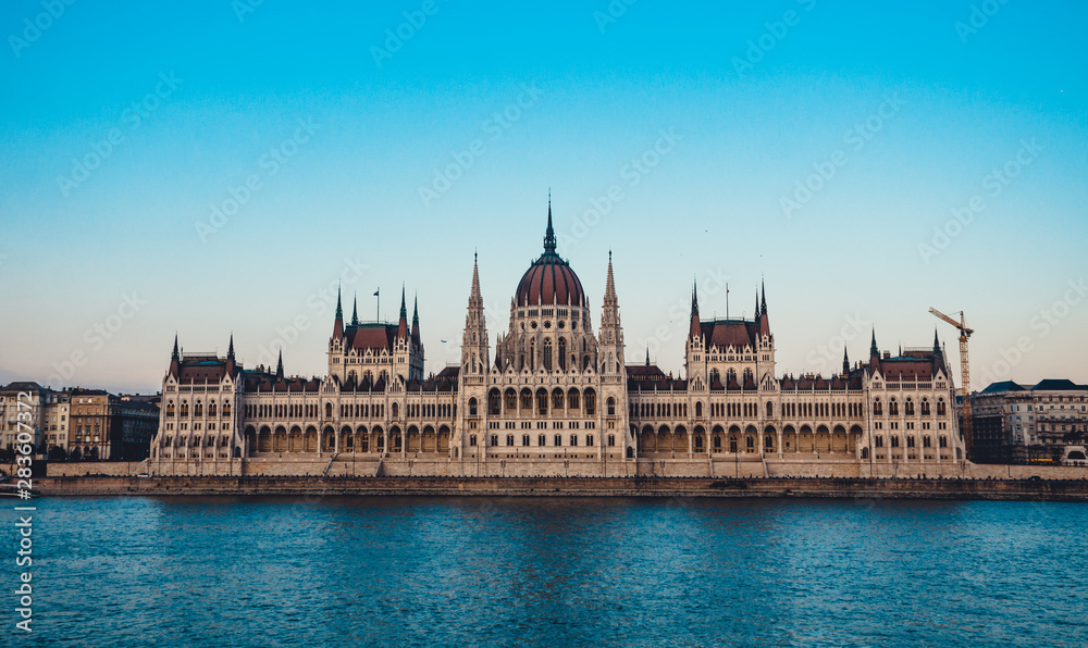 Fototapeta premium Budapest parliament on the Danube at the daytime. Blue clear sky. Tourist destination. Natural colours