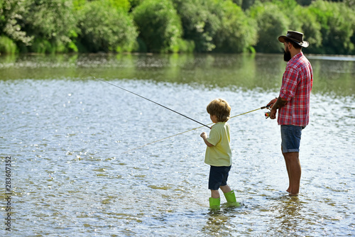 Father and son fishing. Little helper fishing. Father and Son fishing - Family Time Together. Happy family concept - father and son together fishing.