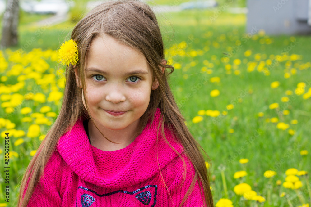 Cute little girl is sitting in a field with dandelions. Cute little girl is sitting in a field with dandelions.