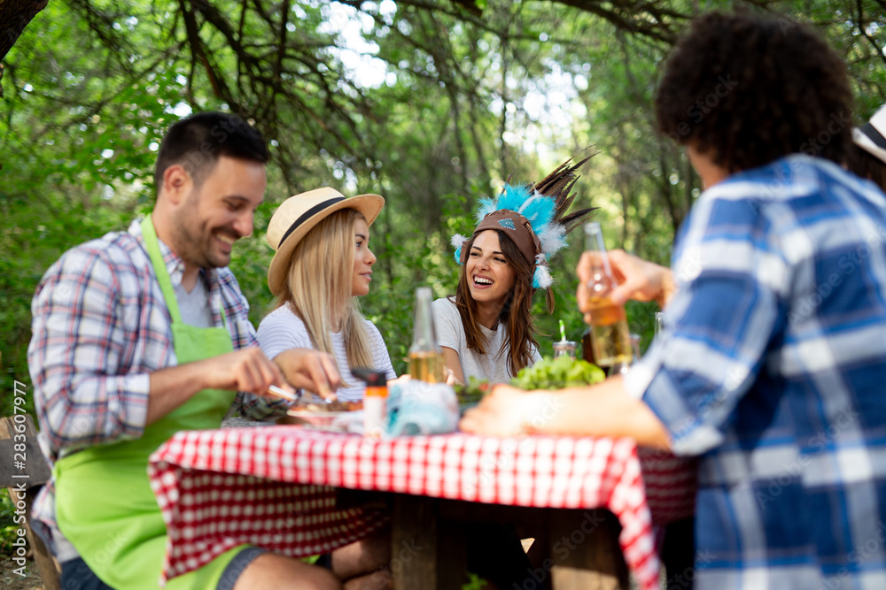 Group of happy friends having a barbecue party in nature Group of happy friends having a barbecue party in nature