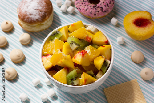 Fruit salad and donuts. Tasty breakfast