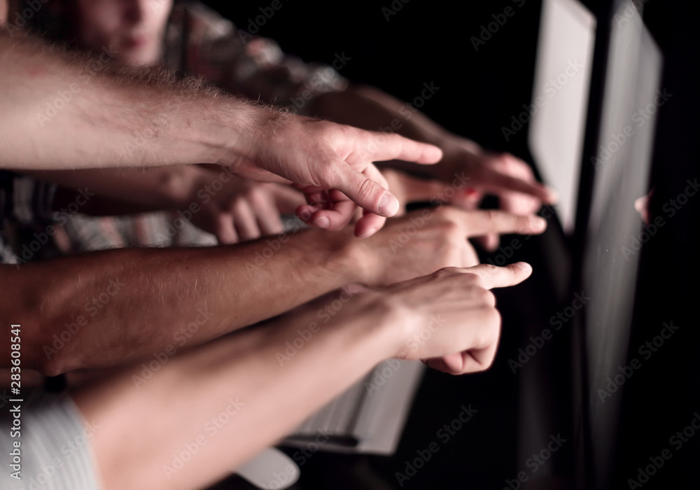 business team pointing their fingers at the computer screen