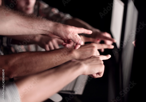 business team pointing their fingers at the computer screen