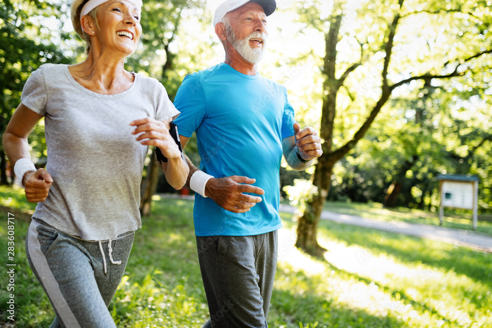 Senior couple jogging and running outdoors in nature Senior couple jogging and running outdoors in nature