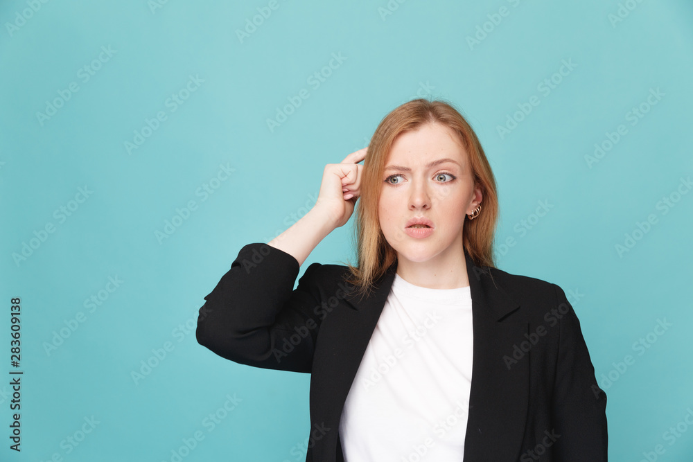 Female person standing confused in a blue studio Female person standing confused in a blue studio