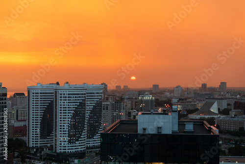 Orange sunset and smog over the evening city. © Roman Penderev