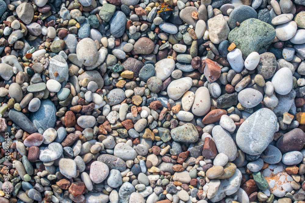 Different size pebbles on the beach. Stone background image.
