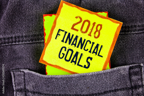 Text sign showing 2018 Financial Goals. Conceptual photo New business strategy earn more profits less investment written Yellow Sticky Note Paper placed the Jeans background.
