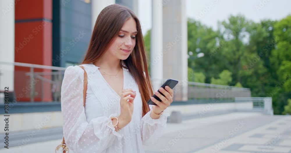 A young lady using a mobile phone outdoors. A young lady using a mobile phone outdoors.