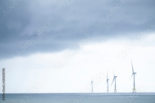 Wind turbines at electric power farm in the North Sea in Aberdeen for renewable energy production and environment conservation