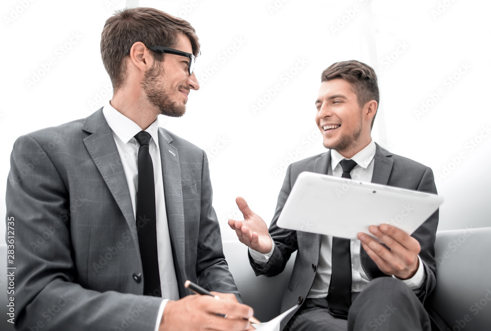 two men chatting while sitting in the office two men chatting while sitting in the office
