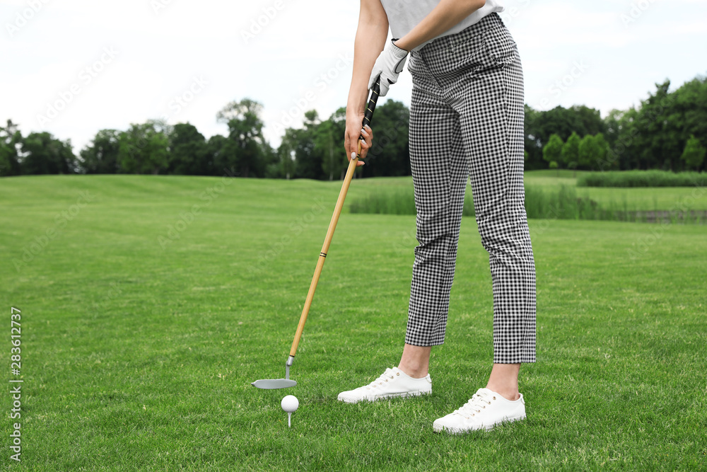 Woman playing golf on green course. Sport and leisure