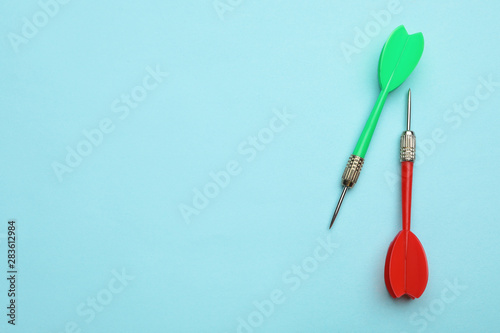 Plastic dart arrows on blue background  flat lay with space for text