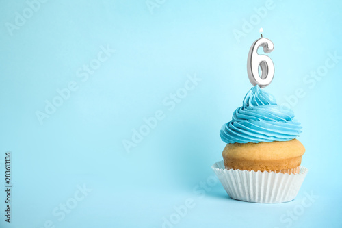 Photography Birthday cupcake with number six candle on blue background, space for text
