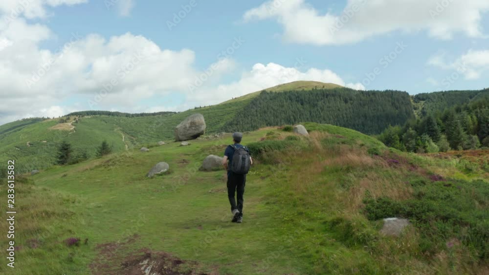 Aerial Flight view of photographer hiking on Cloughmore Stone area, Kilbroney Park,countryside Northern Ireland. Hiking And Tourism Concept Aerial Flight view of photographer hiking on Cloughmore Stone area, Kilbroney Park,countryside Northern Ireland. Hiking And Tourism Concept