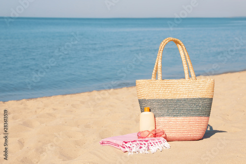 Stylish beach accessories on sand near sea. Space for text