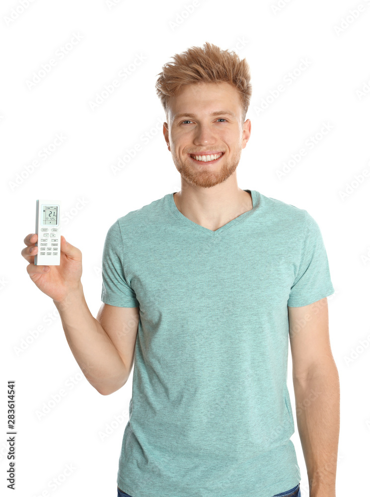 Young man with air conditioner remote on white background