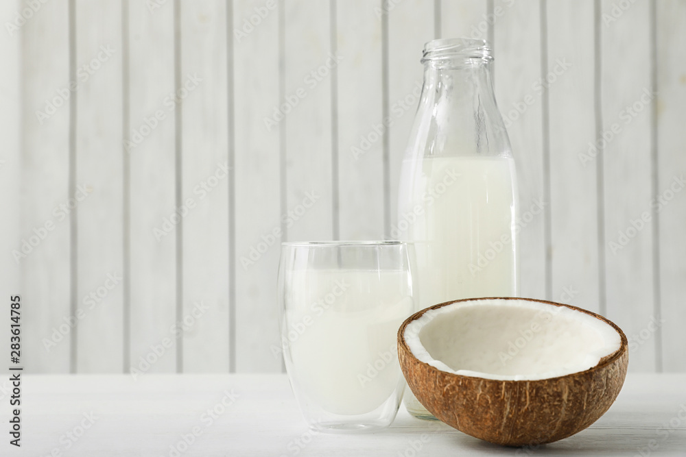 Composition with bottle and glass of coconut water on white wooden table. Space for text Composition with bottle and glass of coconut water on white wooden table. Space for text