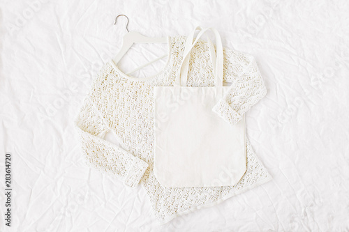 Knitted white sweater with tote bag. Autumn/winter fashion clothes collage on white background. Top view flat lay.