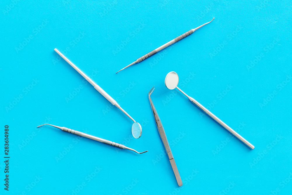 Dentist work desk with tools for teeth on blue background top view Dentist work desk with tools for teeth on blue background top view