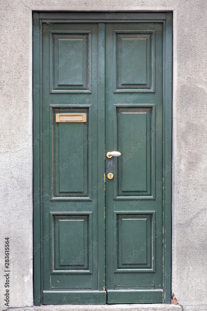 green wood door of building in Como Italy