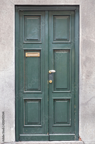 green wood door of building in Como Italy