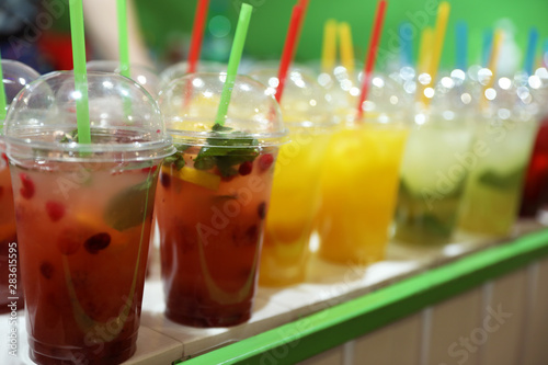 Plastic cups with refreshing drinks on bar counter