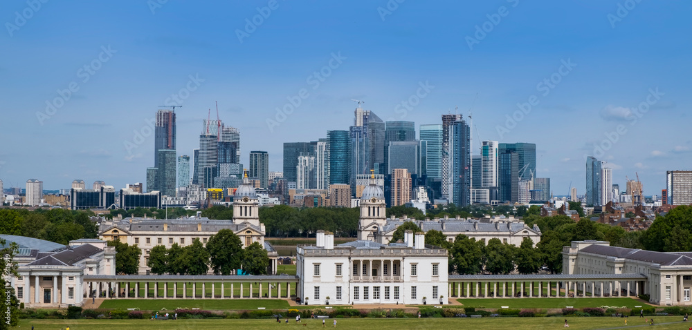 City of London, United Kingdom 6th August 2019: London skyline, Canary Wharf business centre seen from Greenwich. Classical buildings in foreground on summer day