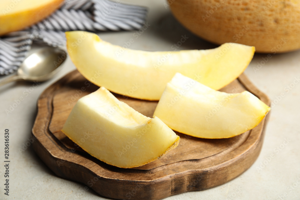 Wooden board with slices of ripe melon on table, closeup Wooden board with slices of ripe melon on table, closeup
