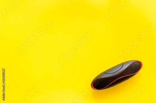 Portable wireless speakers as gadgets for listen to the music on yellow background top view space for text