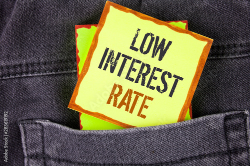 Handwriting text writing Low Interest Rate. Concept meaning Manage money wisely pay lesser rates save higher written Sticky Note Paper placed the Jeans background.