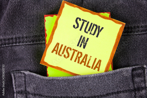 Handwriting text writing Study In Australia. Concept meaning Graduate from oversea universities great opportunity written Sticky Note Paper placed the Jeans background.