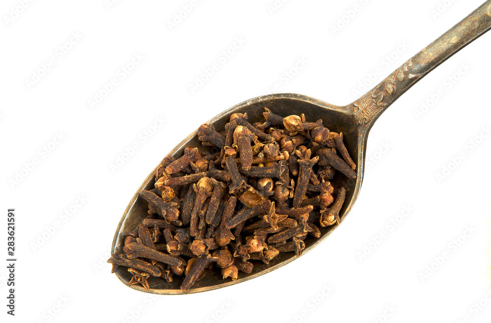 Dry cloves in a spoon isolated on a white background. Spice on isolate. View from above. Dry cloves in a spoon isolated on a white background. Spice on isolate. View from above.