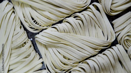 Detailed sppining top view of raw tagliarini pasta. photo