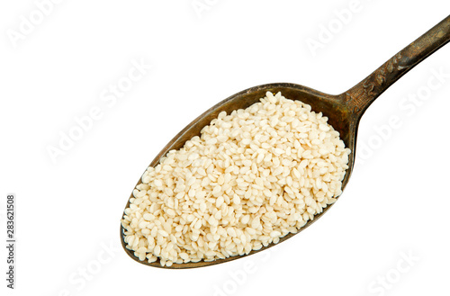 White sesame in a spoon isolated on a white background. Spice on isolate. View from above.