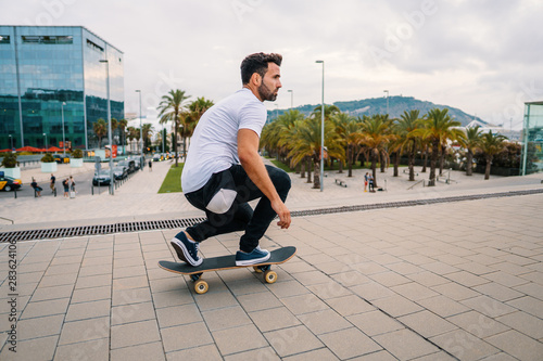 Skateboarder rides a skateboard in the modern city street