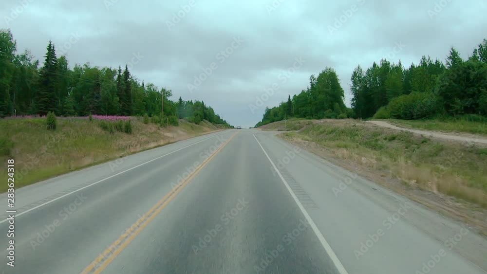 POV through the front windshield while driving on the Sterling Highway in Alaska; several crossroads visible POV through the front windshield while driving on the Sterling Highway in Alaska; several crossroads visible