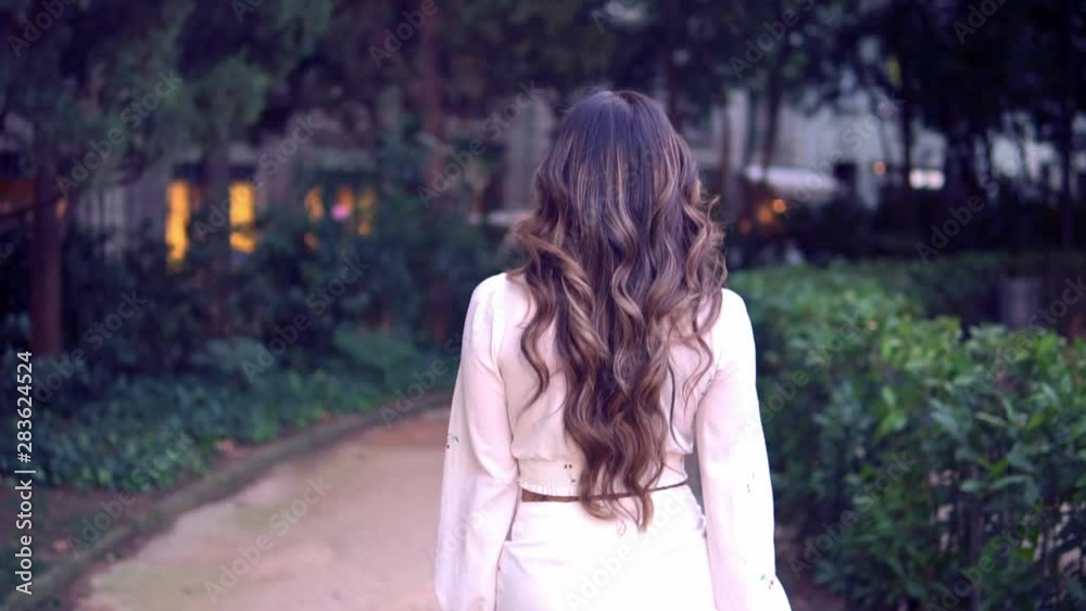 Beautiful Asian girl walking in the park. She is wearing white dress. Happy video Beautiful Asian girl walking in the park. She is wearing white dress. Happy video