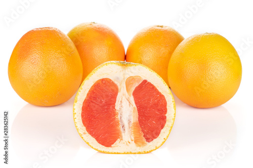 Group of four whole one half of fresh pink grapefruit arranged symmetrically isolated on white background