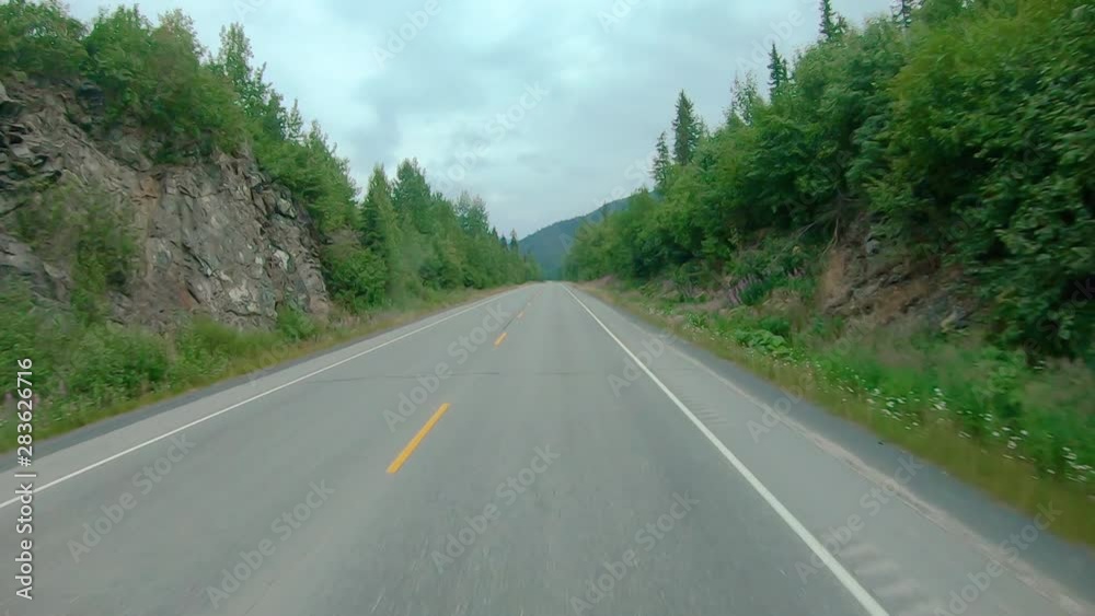 POV through front windshield while driving on the Sterling Highway in Alaska; visible are smoke from local wildfire, Kenai River, Chugach National Forest and Kenai Mountains