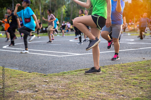 group  women dancing a fitness dance or aerobics on sunlight  in the park photo