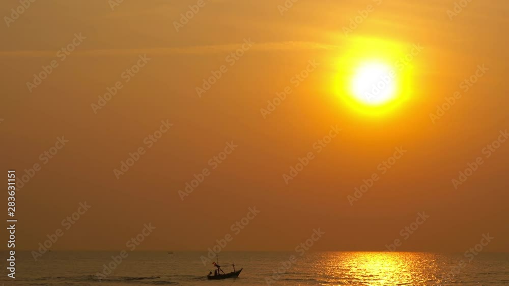 Small fishing boat bouncing across the surface of the sea bathed in the golden light of a gorgeous tropical sunset. Small fishing boat bouncing across the surface of the sea bathed in the golden light of a gorgeous tropical sunset.