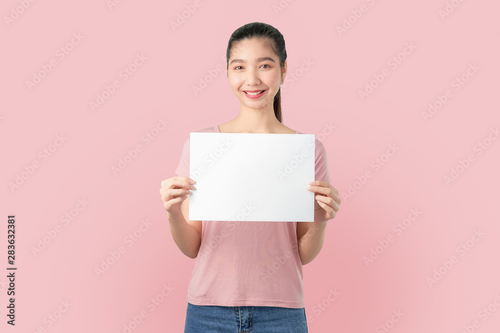 Young Asian woman holding blank paper with smiling face and looking on the blue background. for advertising signs. - obrazy, fototapety, plakaty 