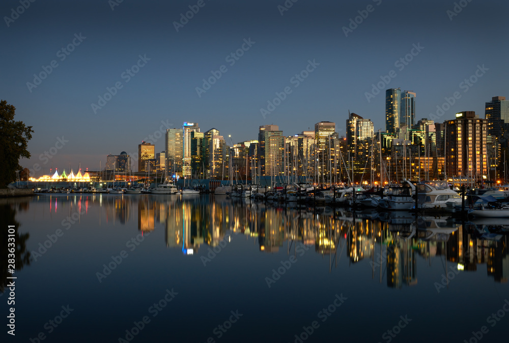 Coal Harbor Skyline Twilight Reflections. A calm Coal Harbor next to Stanley Park at twilight. Vancouver, British Columbia.