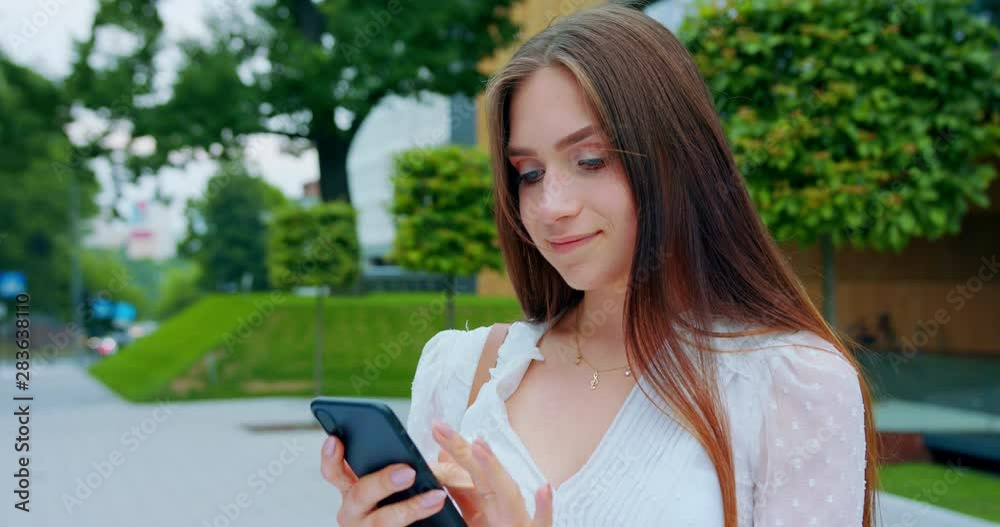 A young lady using a mobile phone outdoors. A young lady using a mobile phone outdoors.