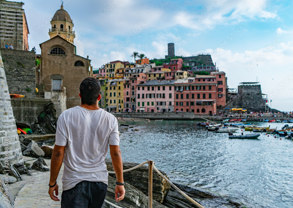 Φωτογραφία Young man walking at the platform near the marina of Vernazza, in Cinque Terre, Italy