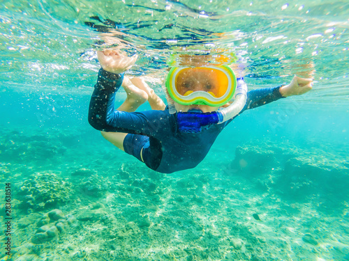Happy family - active kid in snorkeling mask dive underwater, see tropical fish in coral reef sea pool. Travel adventure, swimming activity on summer beach vacation with child