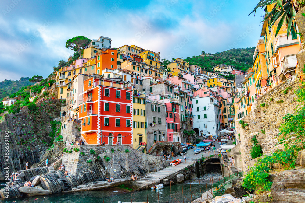 The village of Riomaggiore seen from the marina, in Cinque Terre, Italy. European summer and the Mediterranean sea. Unesco World Heritage Site.