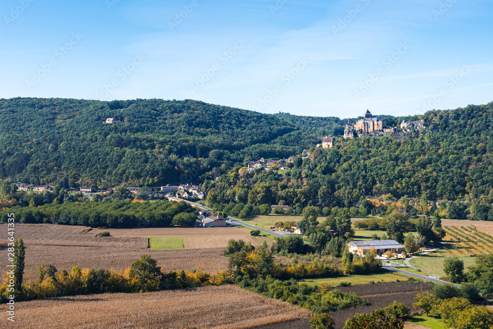 View over farms in the Dordogne valley towards the medieval chateau of Castelnaud-la-Chapelle