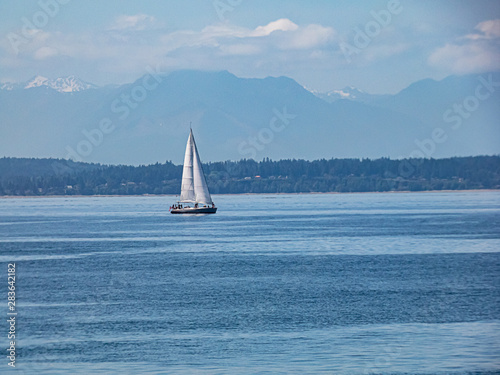 sail boat sailing along shoreline of island in pacific ocean